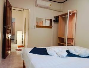 a bedroom with a bed with white sheets and pillows at Little house in Koh Samui