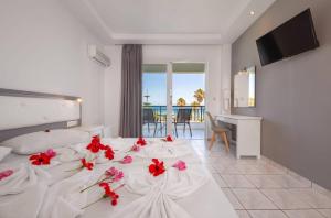 a bedroom with a white bed with red flowers on it at Stella Maris in Kos