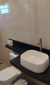 a bathroom with a white toilet and a sink at Ótima localização in Imperatriz