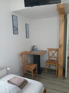 a room with a bed and a table and chairs at Pension Ambiente in Mühlberg