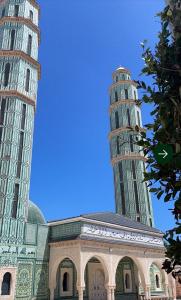 a mosque with two tall towers next to a building at Hostel MJ ,Sidi kbir in Zarzis