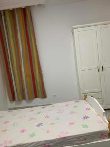 a bedroom with a bed with flowers on it at Hostel MJ ,Sidi kbir in Zarzis