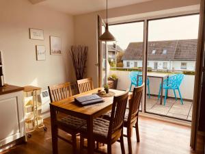 a dining room with a table and chairs and a balcony at Apartment Luise in Friedrichskoog-Spitze +14 photos