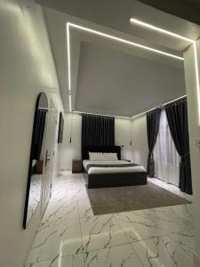 a large bedroom with a bed and a mirror at Olivewood Apartments in Ankuru