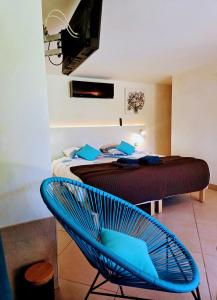 a bedroom with a bed and a blue chair at Villa Perle De La Mer in Saint-Aygulf