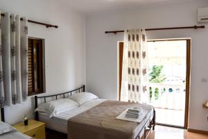 a bedroom with two beds and a large window at Kompleks Angjelo in Lukovë