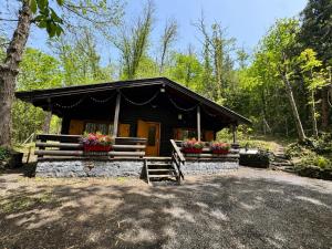 a cabin in the woods with flowers in front of it at Etna Essence Chalet in Trecastagni