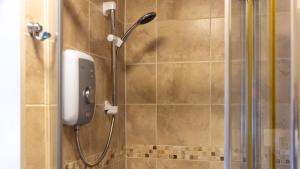 a shower with a shower head in a bathroom at The Poacher Inn in Upton Grey