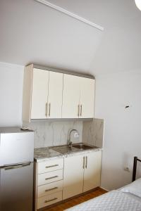 a kitchen with white cabinets and a sink at Kompleks Angjelo in Lukovë +12 photos