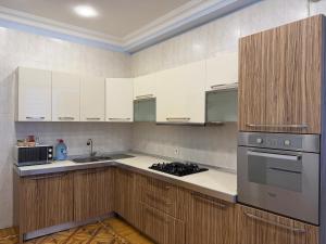 a kitchen with white cabinets and a stove top oven at Mayden Tower apartment in Baku