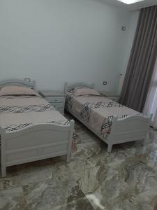two beds sitting next to each other in a bedroom at Casa hersi in Hennchir Ksar Rhaleb