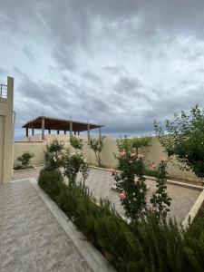 a garden with a pavilion in the back of a building at Casa hersi in Hennchir Ksar Rhaleb