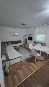 a living room with a large bed and a table at Apartman Anna & Kamp Elza in Bihać