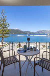 a table and chairs on a balcony with a view of the beach at Cavaliere Seafront House - Theseus in Sami
