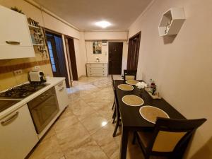 a kitchen with a table with chairs and a stove at COZY PANORAMA Flat in Alba Iulia