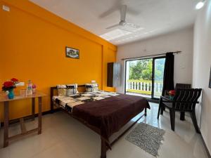 a bedroom with a bed and a desk and a window at Durga Beach Resort in Parxem