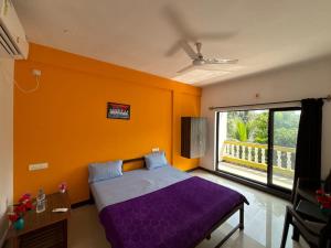 a bedroom with a purple bed and a large window at Durga Beach Resort in Parxem