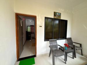 two chairs and a table in a room with a window at Durga Beach Resort in Parxem