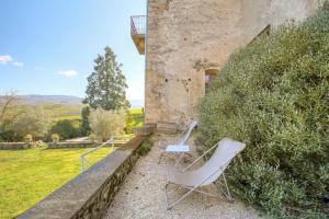 a couple of chairs sitting next to a building at La Vie de Château, proche Lyon in Bessenay
