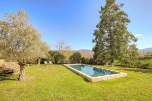 a swimming pool in the middle of a yard with trees at La Vie de Château, proche Lyon in Bessenay