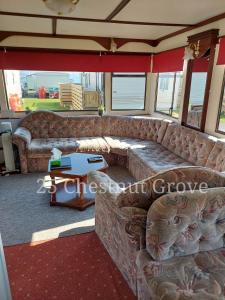 a living room with a couch and a table at 25 Chestnut Grove in Kirkcolm