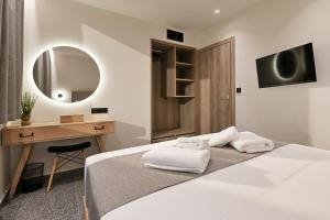 a bedroom with a bed and a desk and a mirror at Vagg Villas in Preveza +48 photos
