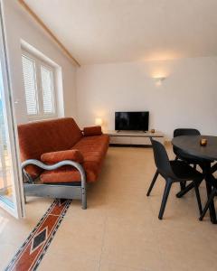 a living room with a couch and a table at App LOLLY in Selce