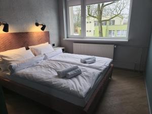 a bedroom with a bed with two pillows on it at Nemunėlio vitražai in Nemunėlio Radviliškis +6 photos