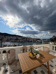 a wooden table with a bowl of fruit on a balcony at Anezo's Exceptional View in Spetses