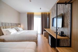 a hotel room with two beds and a television at Tris3 Hotel in Vlorë +58 photos