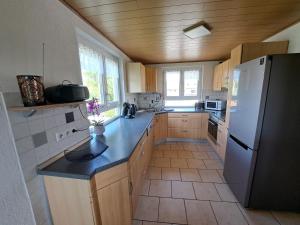 a kitchen with a white refrigerator and wooden cabinets at Gästehaus Kienle in Rot an der Rot