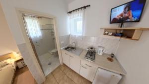 a bathroom with a sink and a tv on the wall at Cozy and practical studio in avonija in Murine