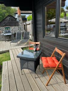 a patio with a table and chairs on a porch at Greenwood Chalet in Ottershaw