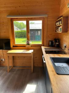 a kitchen with a window in a wooden cabin at Greenwood Chalet in Ottershaw +5 photos