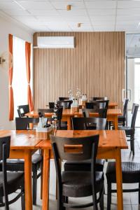 a dining room with wooden tables and chairs at Solea Family Hotel & Restaurant l Free Parking in Ravda