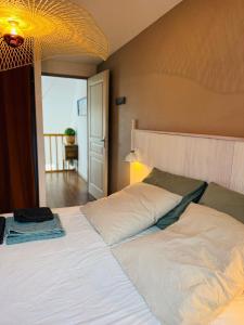 a bedroom with a large white bed with a light at Appartement duplex vue mer in Audierne +37 photos