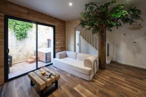 a living room with a white couch and a tree at La Maison Cabane in Cholet +38 photos