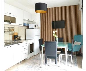 a kitchen with a dining room table and chairs at Apartment BayView in Donji Morinj