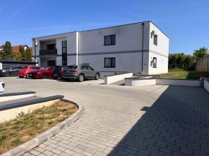 a building with cars parked in a parking lot at Trend Apartman in Bük