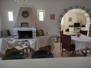 a living room with a table and a fireplace at Pera Horio House in Apérathos