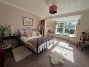 a bedroom with a bed and a window at Elmsleigh in Marhamchurch