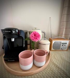 a table with a coffee maker and a pink flower at Elmsleigh in Marhamchurch