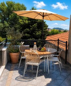 a table and chairs with an umbrella on a patio at Romantic loft in Tríkala