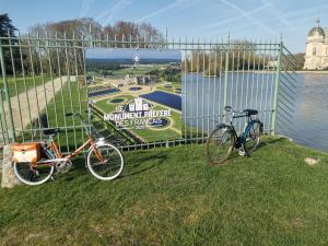two bikes parked on the grass next to the water at Augrenierdelachaumine in Précy-sur-Oise