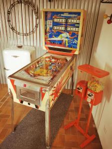 a pinball machine in a room with a table at Augrenierdelachaumine in Précy-sur-Oise