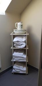 a stack of towels on a shelf in a bathroom at La Peuterne in Mouazé