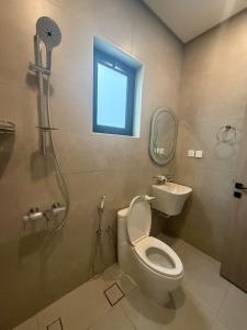 a bathroom with a toilet and a sink and a window at AURA Stay in Dammam +15 photos
