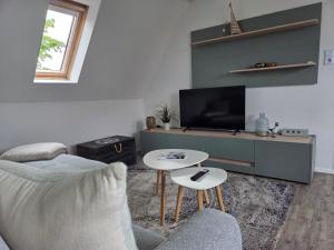 a living room with a couch and a tv at Pension Zur Brandung in Büsum