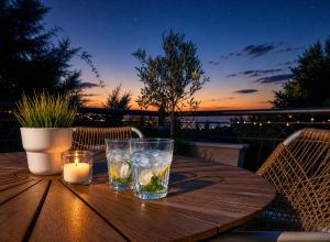 a wooden table with two glasses and a candle on it at Romantic loft in Tríkala
