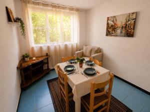 a dining room with a table and chairs and a window at Apartman Mediteran in Herceg-Novi
